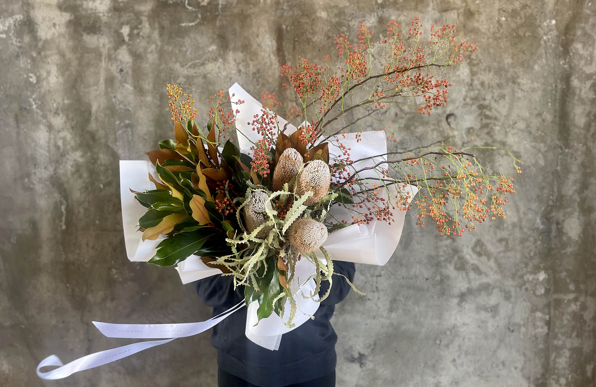 March Birthday Flower bouquet being held by florist containing seasonal flowers in Autumn hues