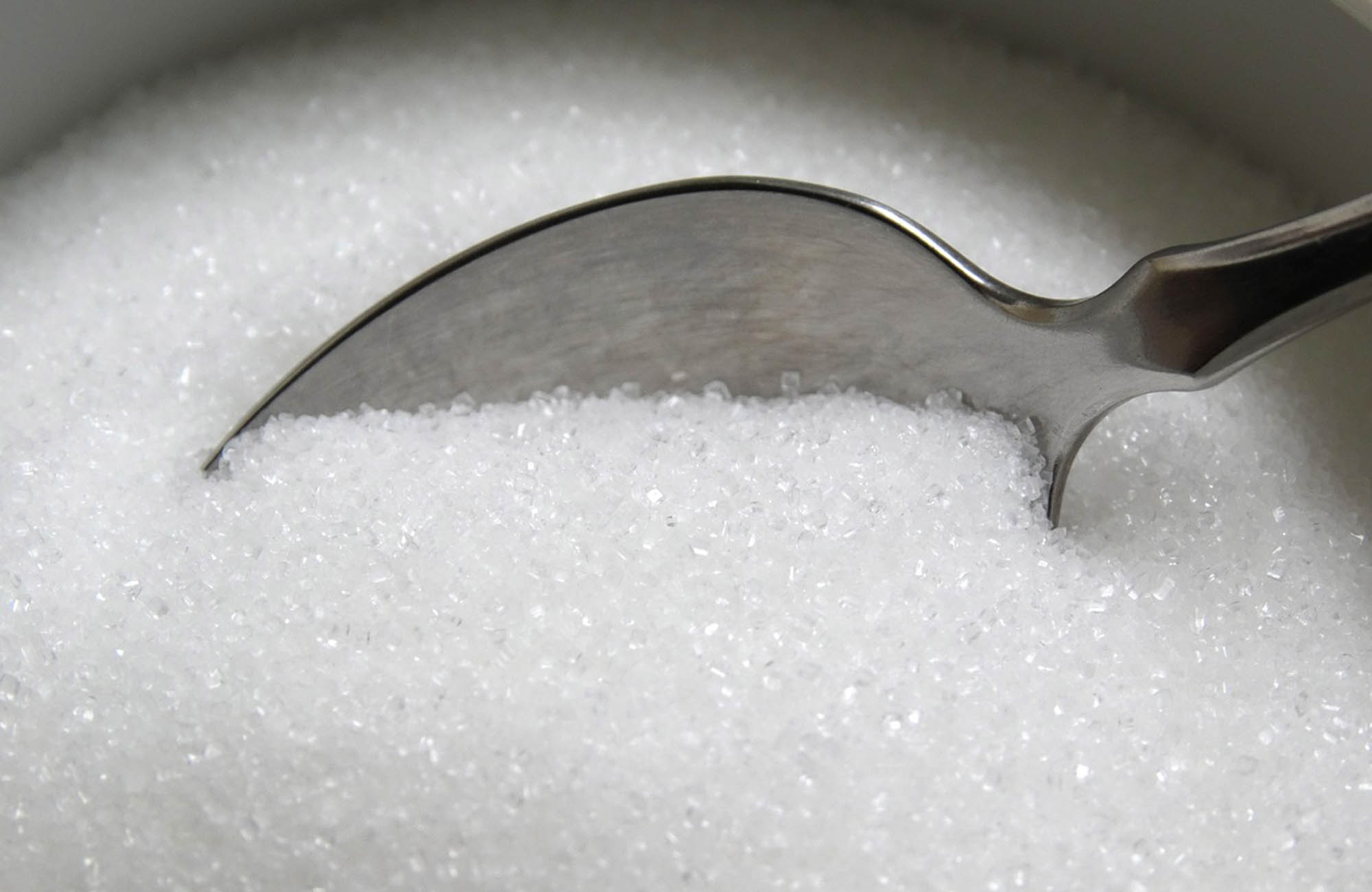 Spoon scooping up sugar to make flower food