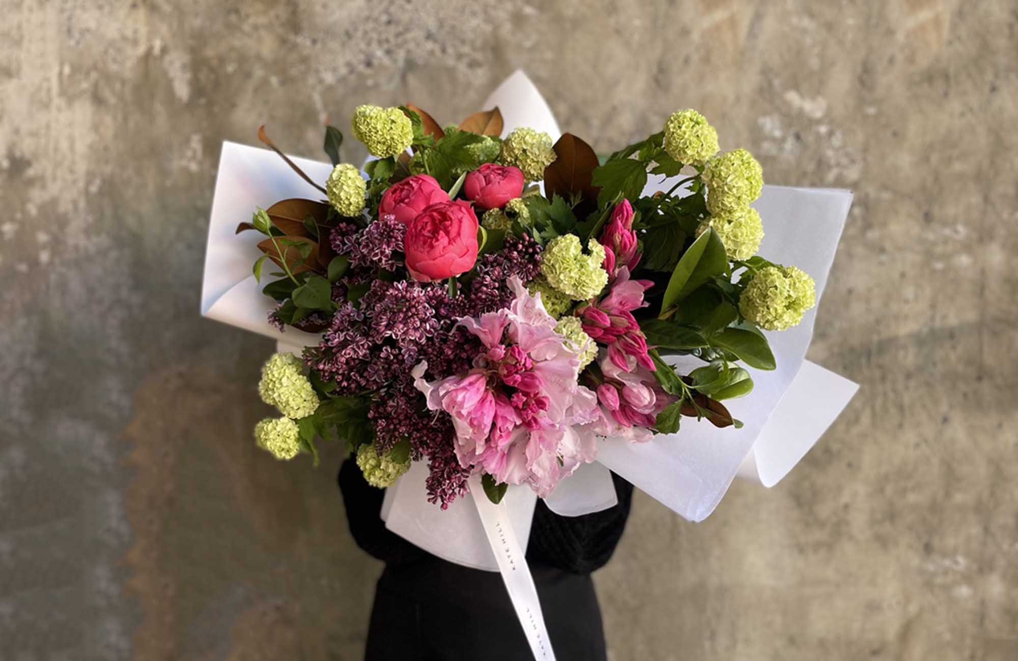 Flower bouquet featuring multiple Australian Spring flower varieties on a textured wall backdrop