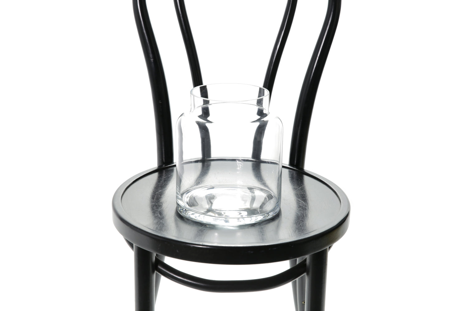 Close up image of glass vase. 20cm lipped cylinder vase sitting on a black bentwood chair with a white background.