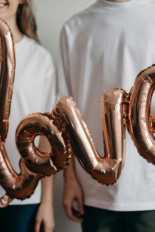 Love balloon being held by couple celebrating their anniversary
