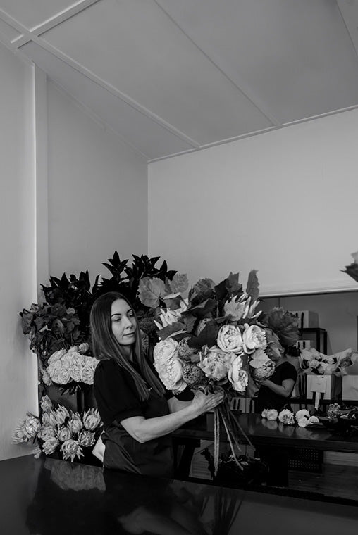 Melbourne florist arranging artificial flowers in a studio setting
