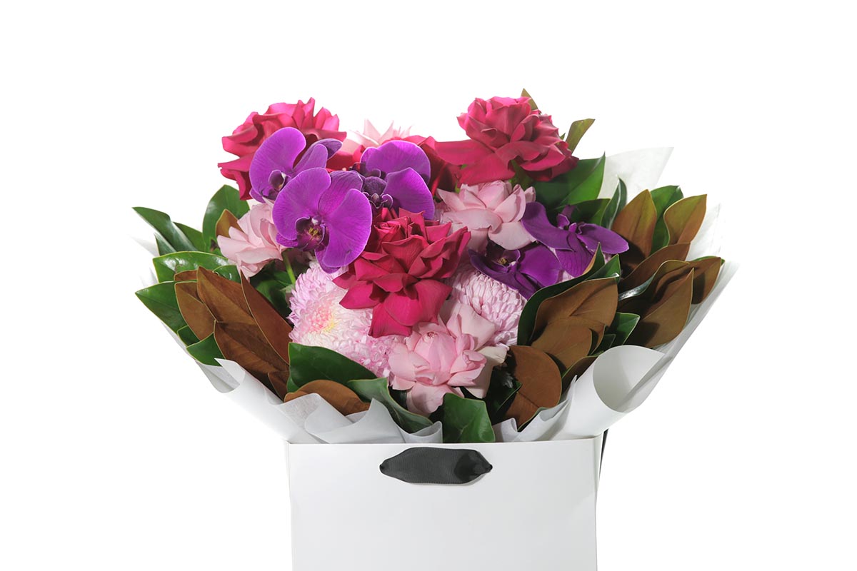 Kate Hill Flowers – large bright-pink birthday bouquet of roses, chrysanthemums, orchids and magnolia foliage, hand-tied.