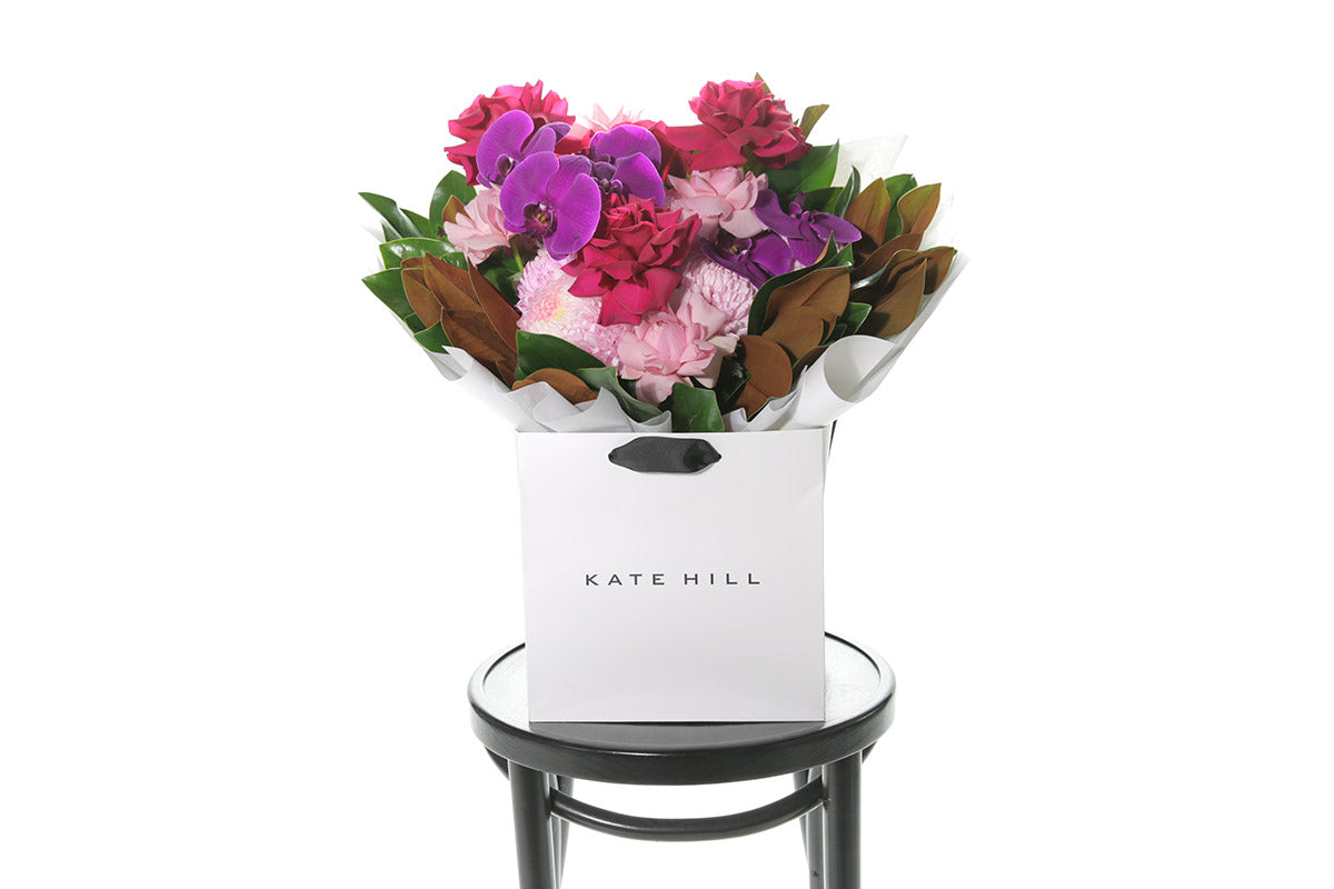 Kate Hill Flowers – large bright-pink birthday bouquet of roses, chrysanthemums, orchids and magnolia foliage, hand-tied.