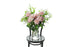 Soft blush pink reflexed roses displayed in a clear glass tapered vase sitting on a black bentwood chair with white background.