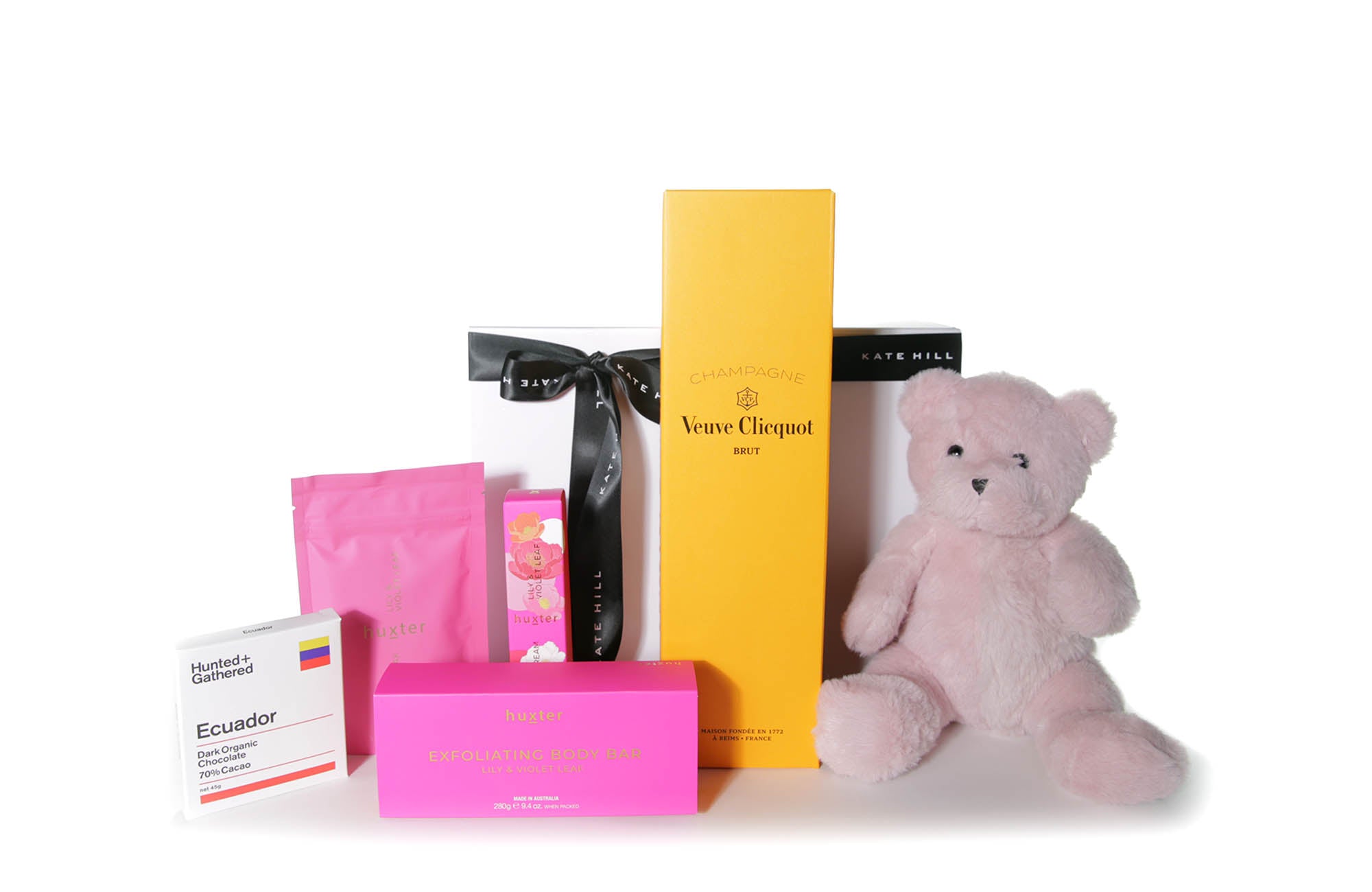 Gift box hamper featuring chocolate, French Champagne, body care products and a teddy bear.