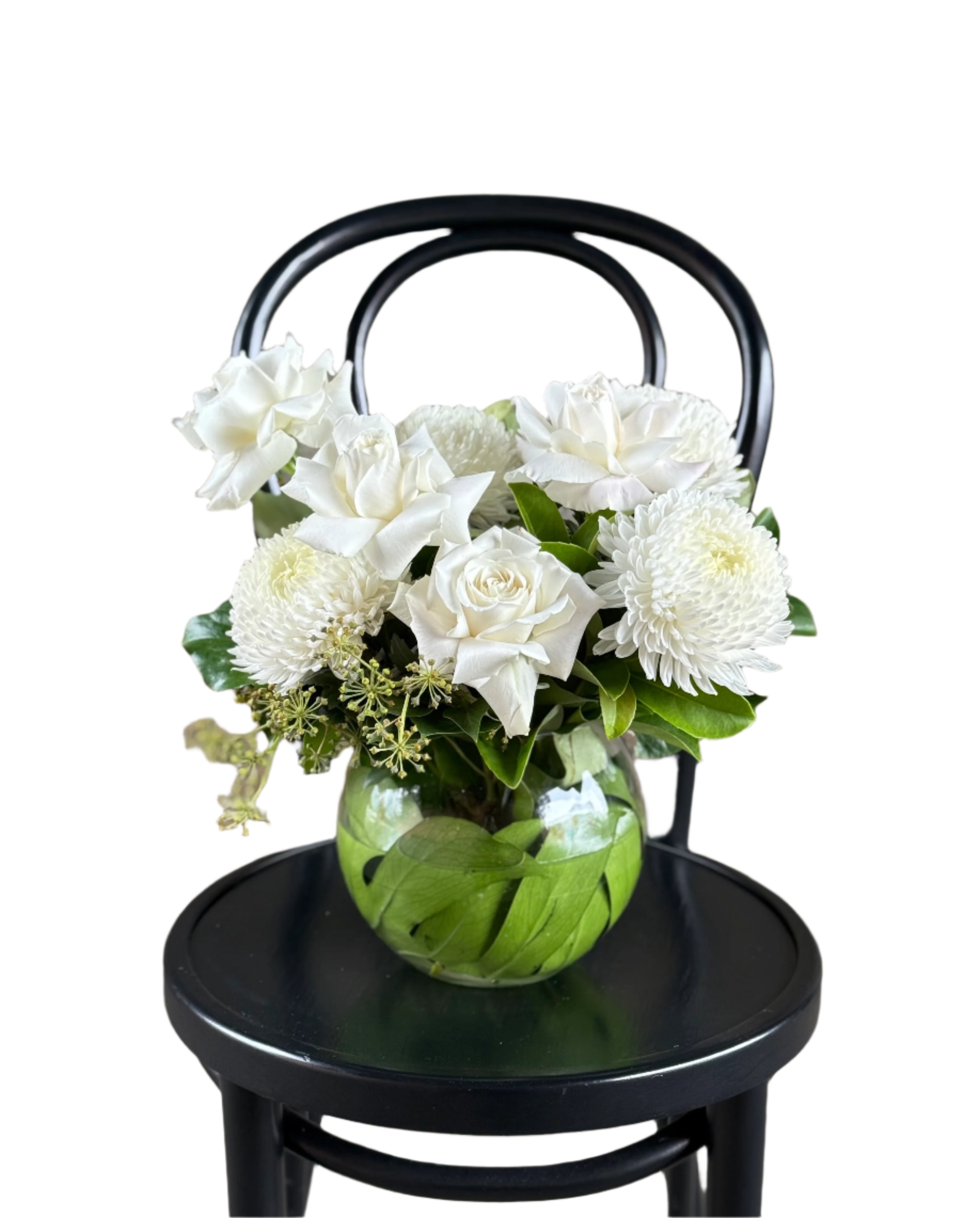 A classic white and green ball vase design sitting on a black bentwood chair.