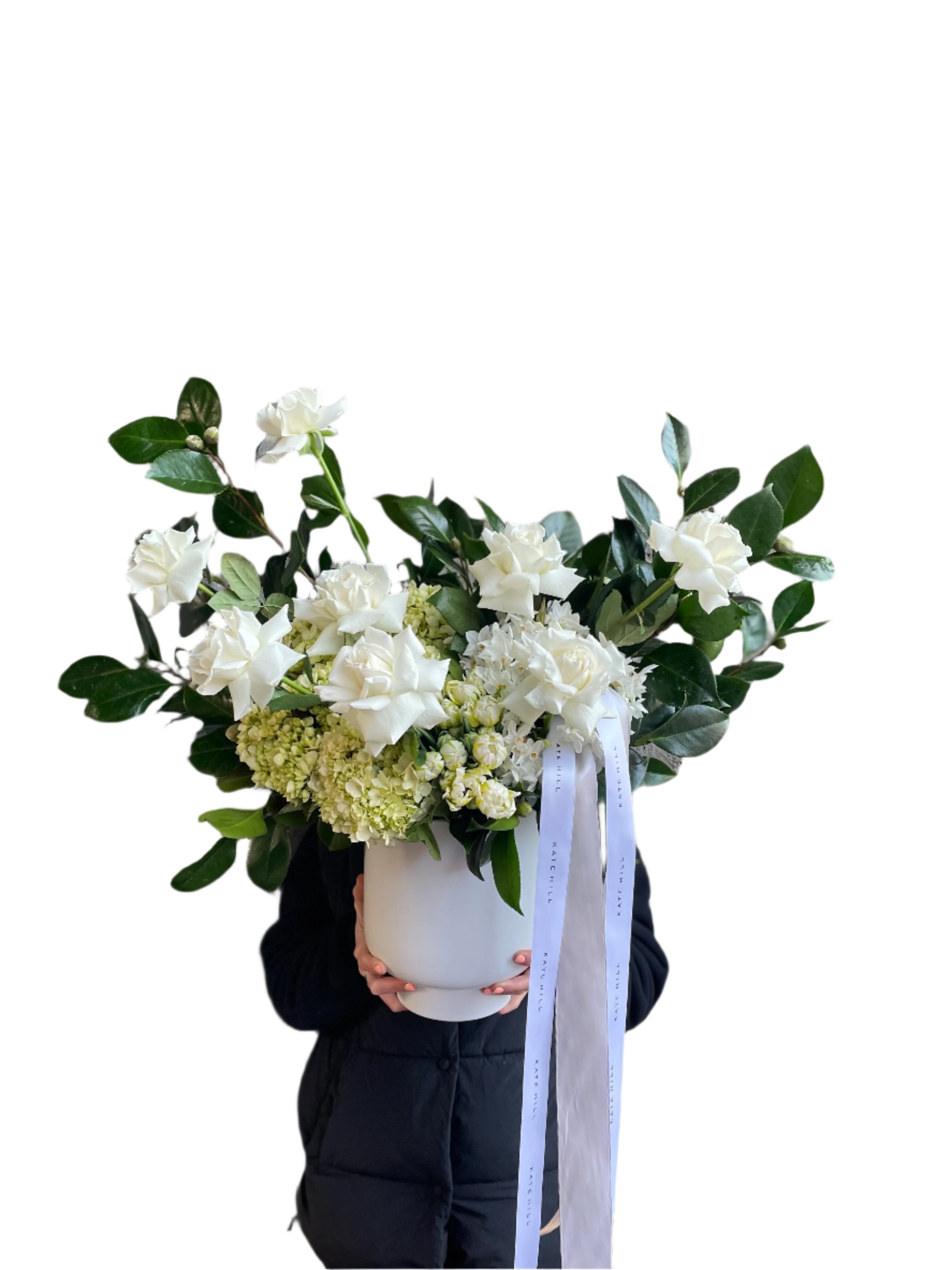 A large luxe white flower design sitting on a black bentwood chair with white wall behind.