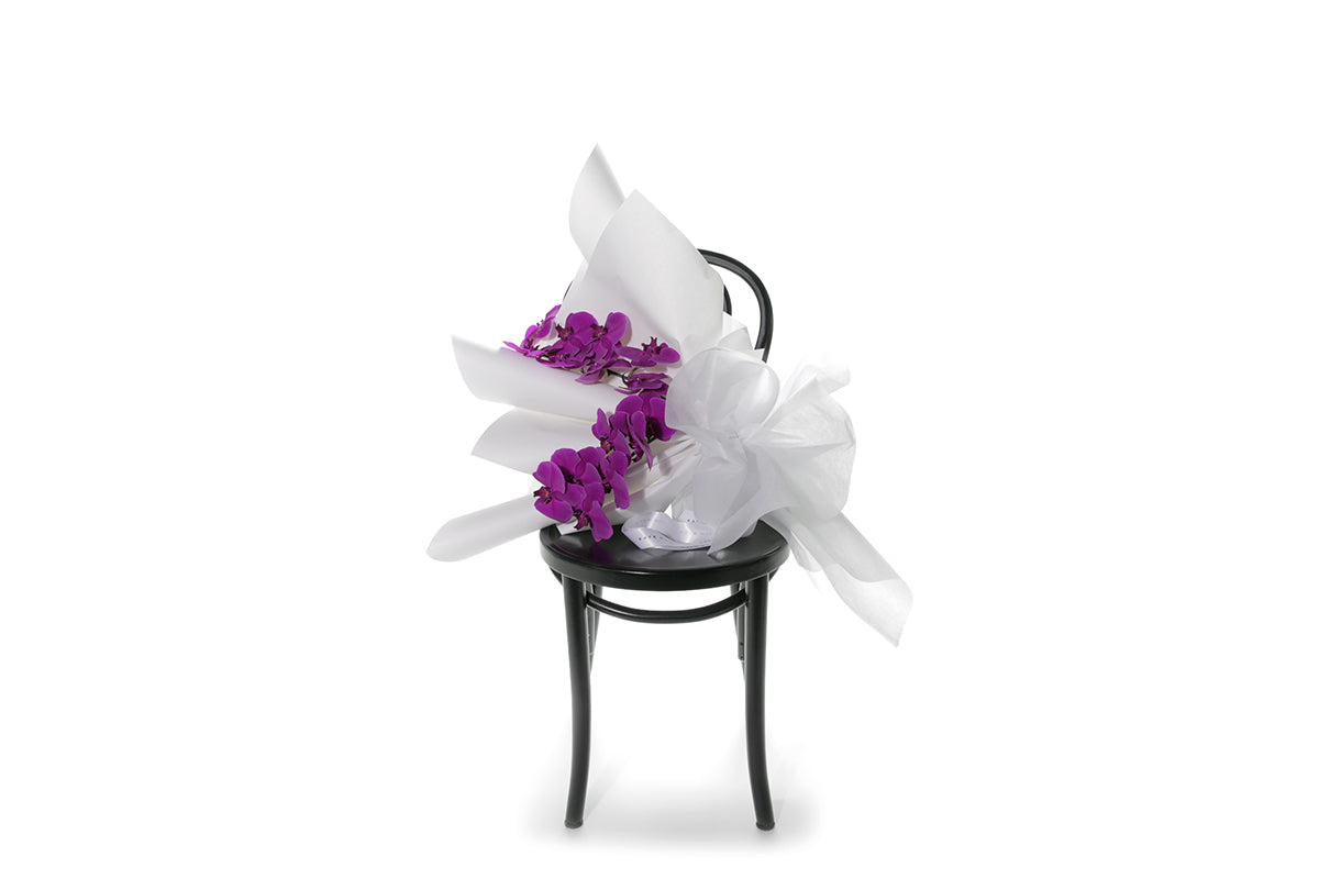 Kate Hill Flowers – gift-wrapped magenta Phalaenopsis orchid bouquet with two water-vialled stems.
