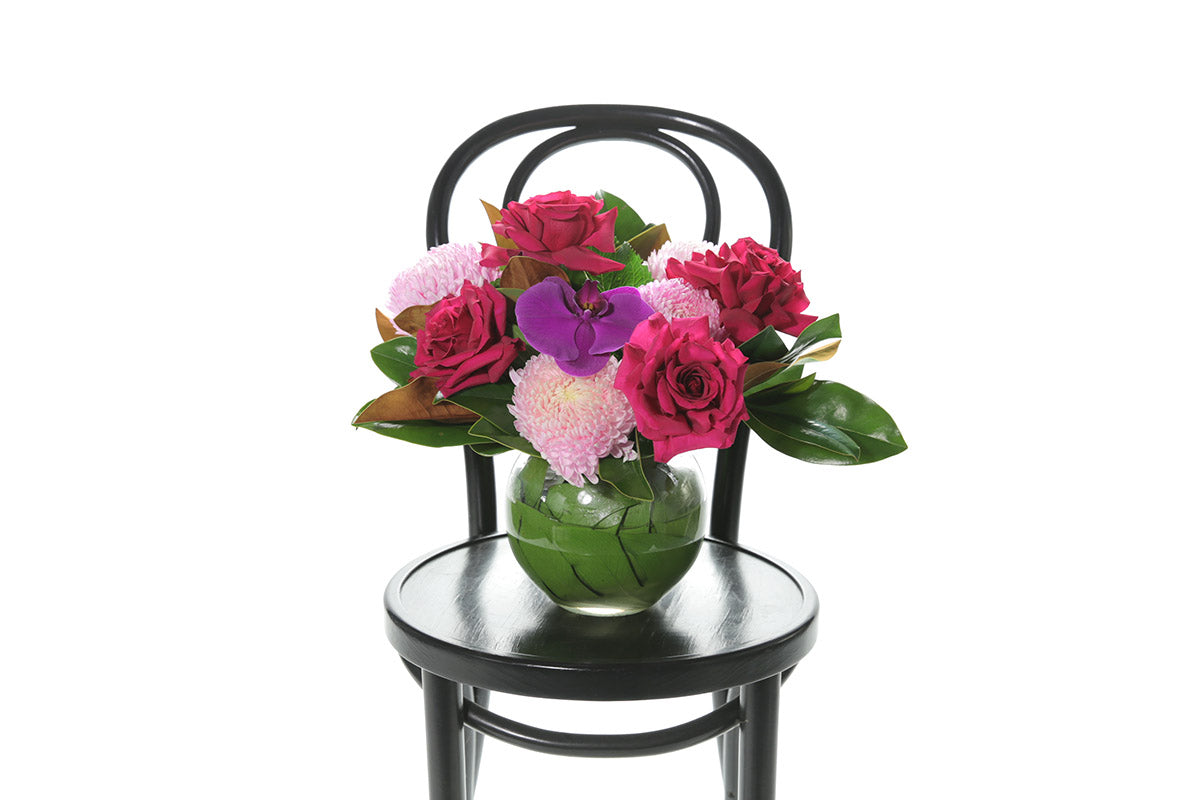 Kate Hill Flowers – bright pink ball-vase birthday design with chrysanthemums, reflexed roses and magenta orchid.