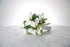 White wedding flower bouquet on a marble surface with a white background