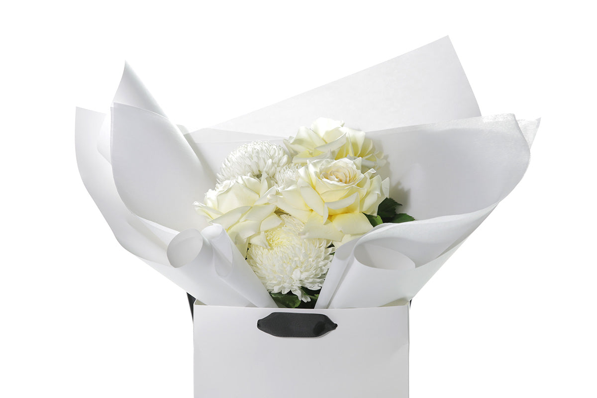 Kate Hill Flowers – small white and lemon congratulations posy of roses and chrysanthemums in a luxury flower bag.