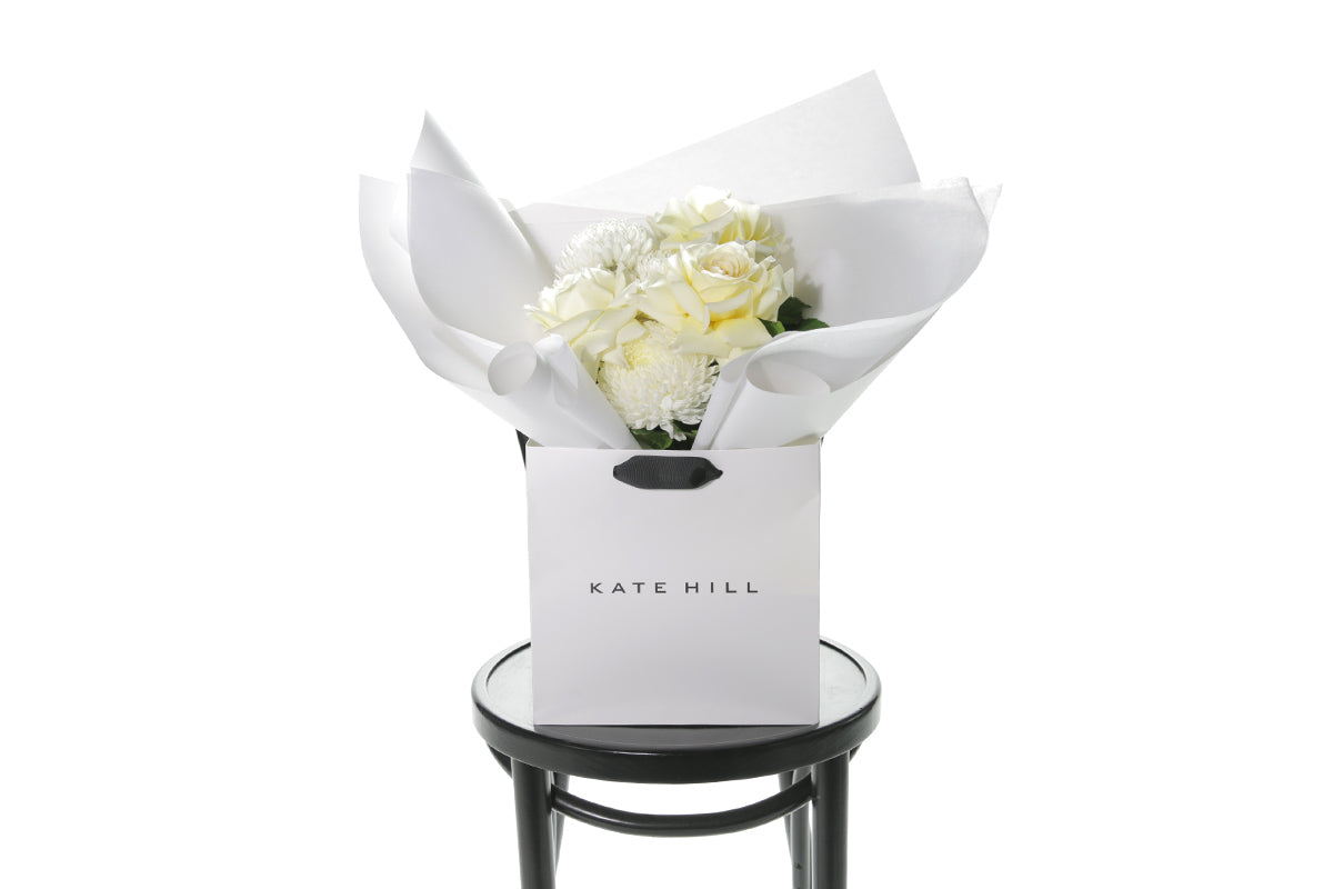 Kate Hill Flowers – small white and lemon congratulations posy of roses and chrysanthemums in a luxury flower bag.