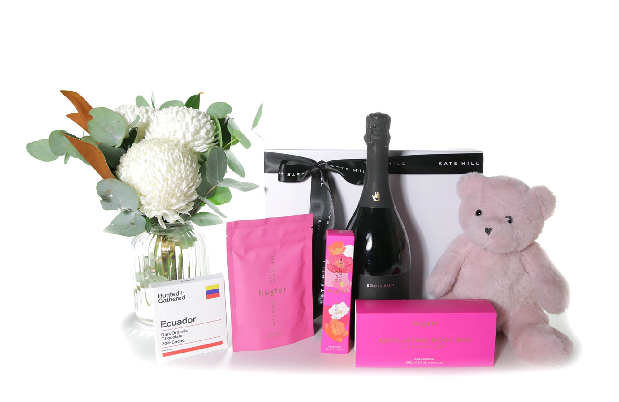 Gift box hamper featuring a chic mini flower vase design, chocolate bar, body products and a teddy bear.