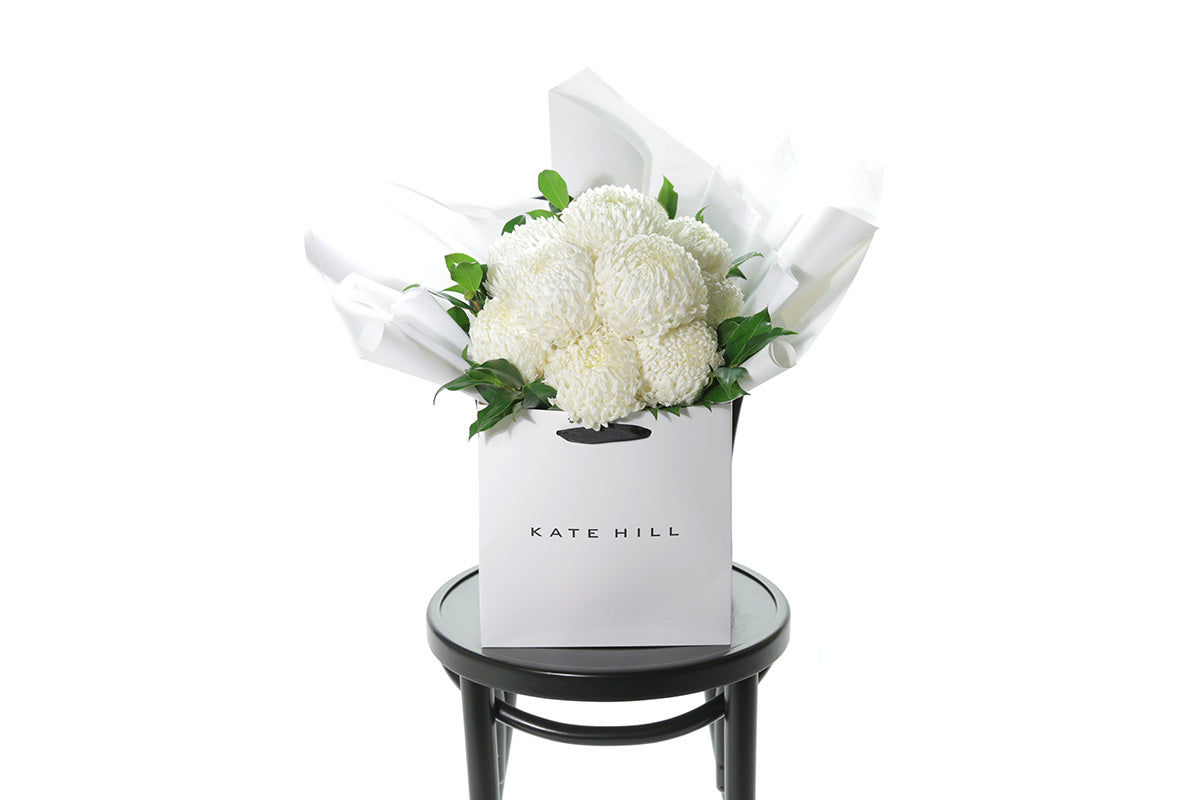 White flower bouquet perfect for sympathy flowers on black bentwood chair for size perspective