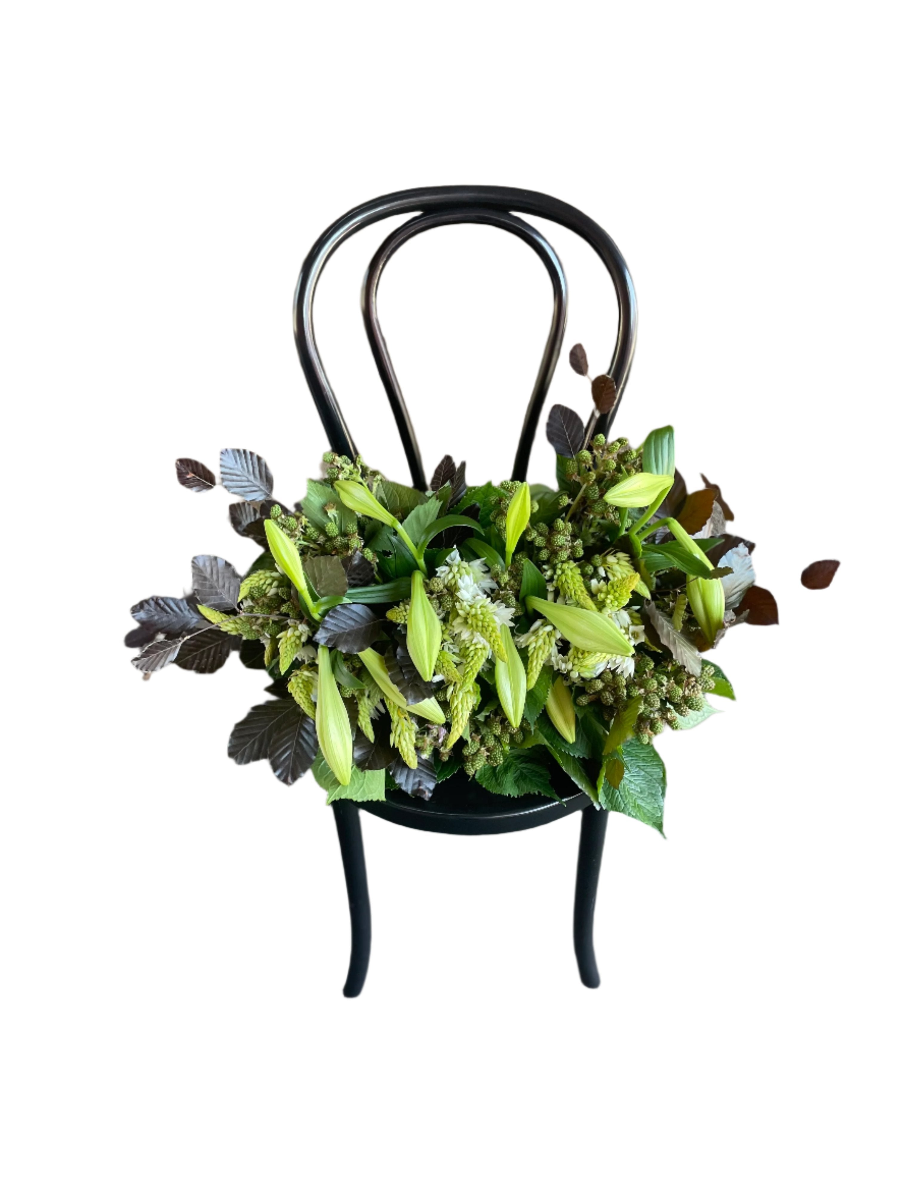 A high image from above of a Christmas Table Design sitting on a black bentwood chair with a white wall background.