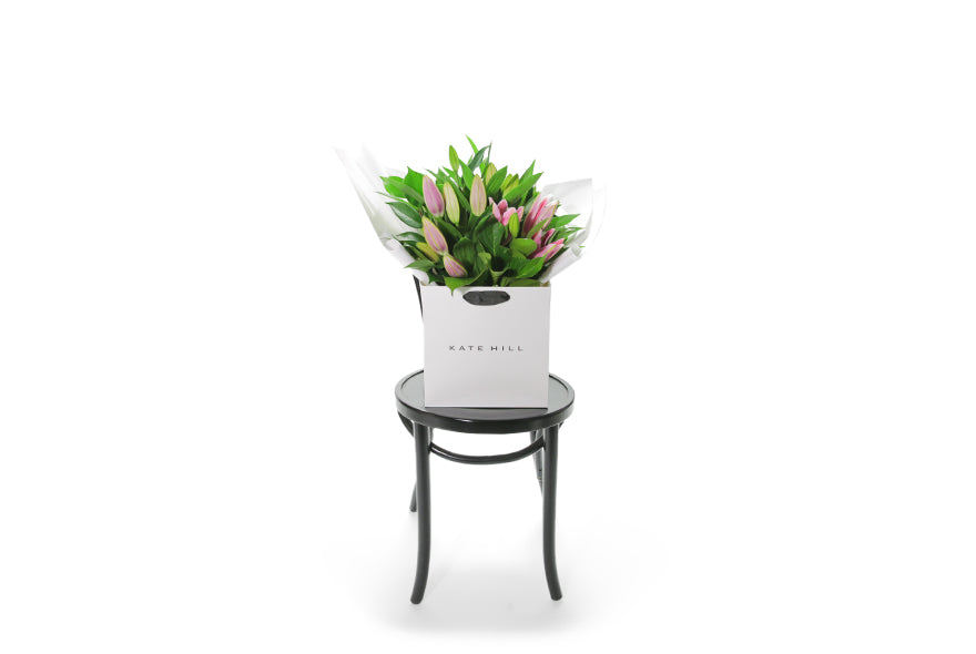 Wide image of the VARDA pink lily bouquet. VARDA Lily Flower Bouquet features a simple bouquet of pink oriental Lilies and green seasonal foliage.