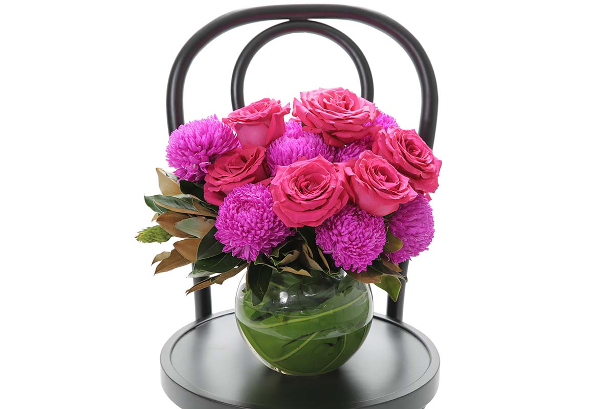 Close-up of MAYA large ball vase with hot pink disbuds and roses