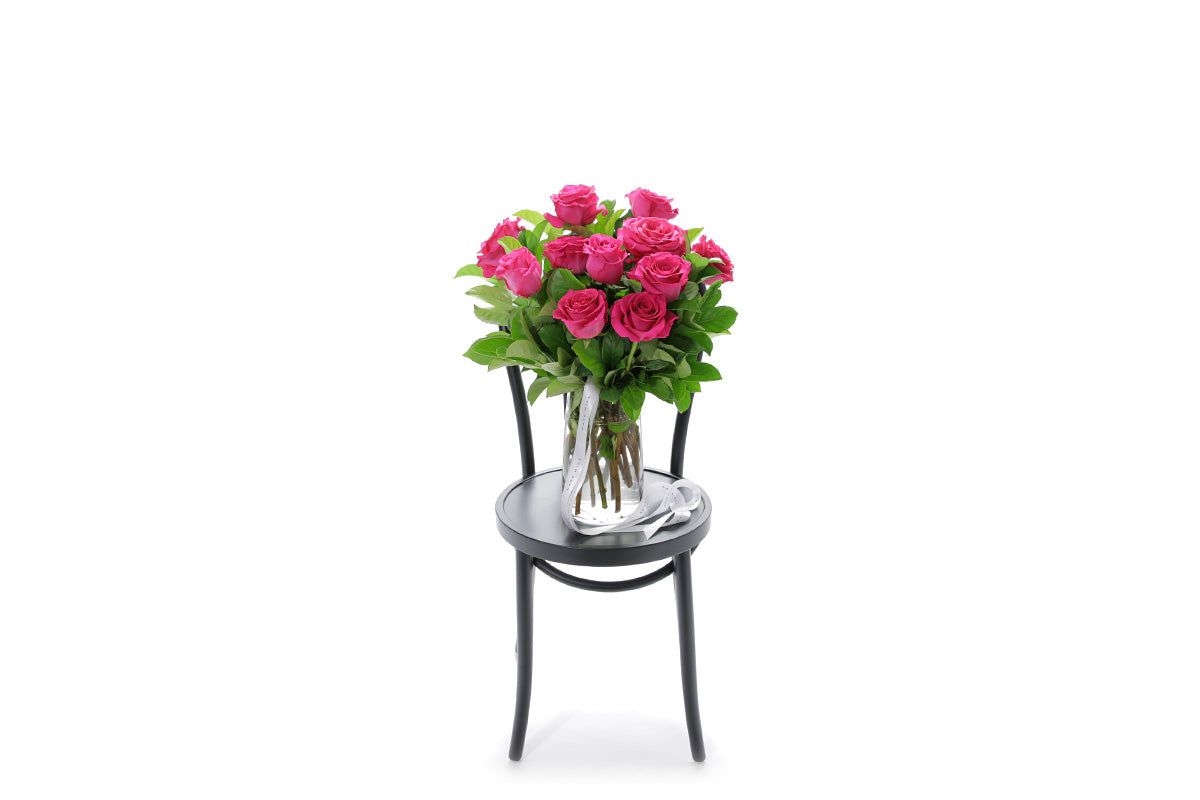 SASKIA hot pink roses in a tapered glass vase lined with monsteria