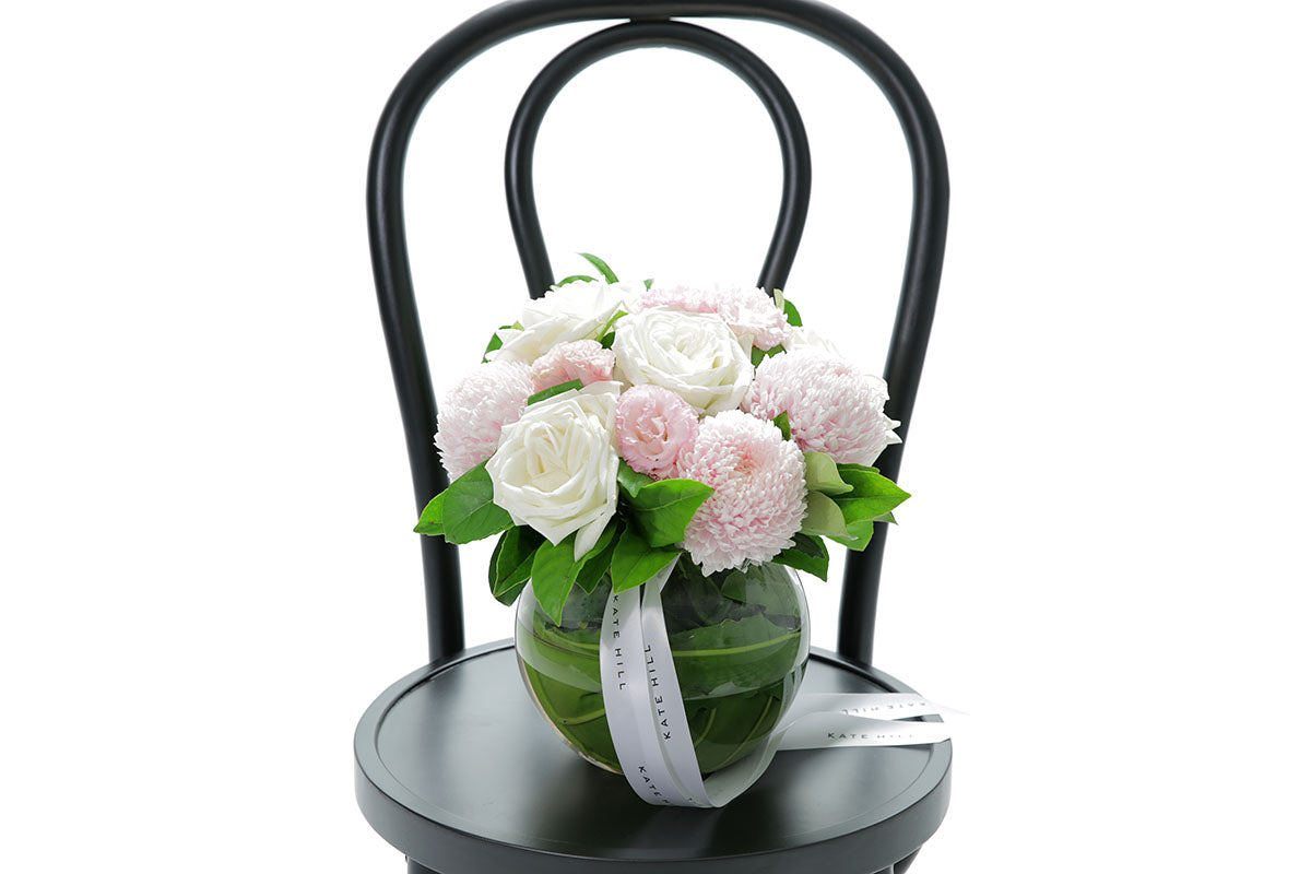 Close-up of SERENITY ball vase with blush and white disbuds and roses