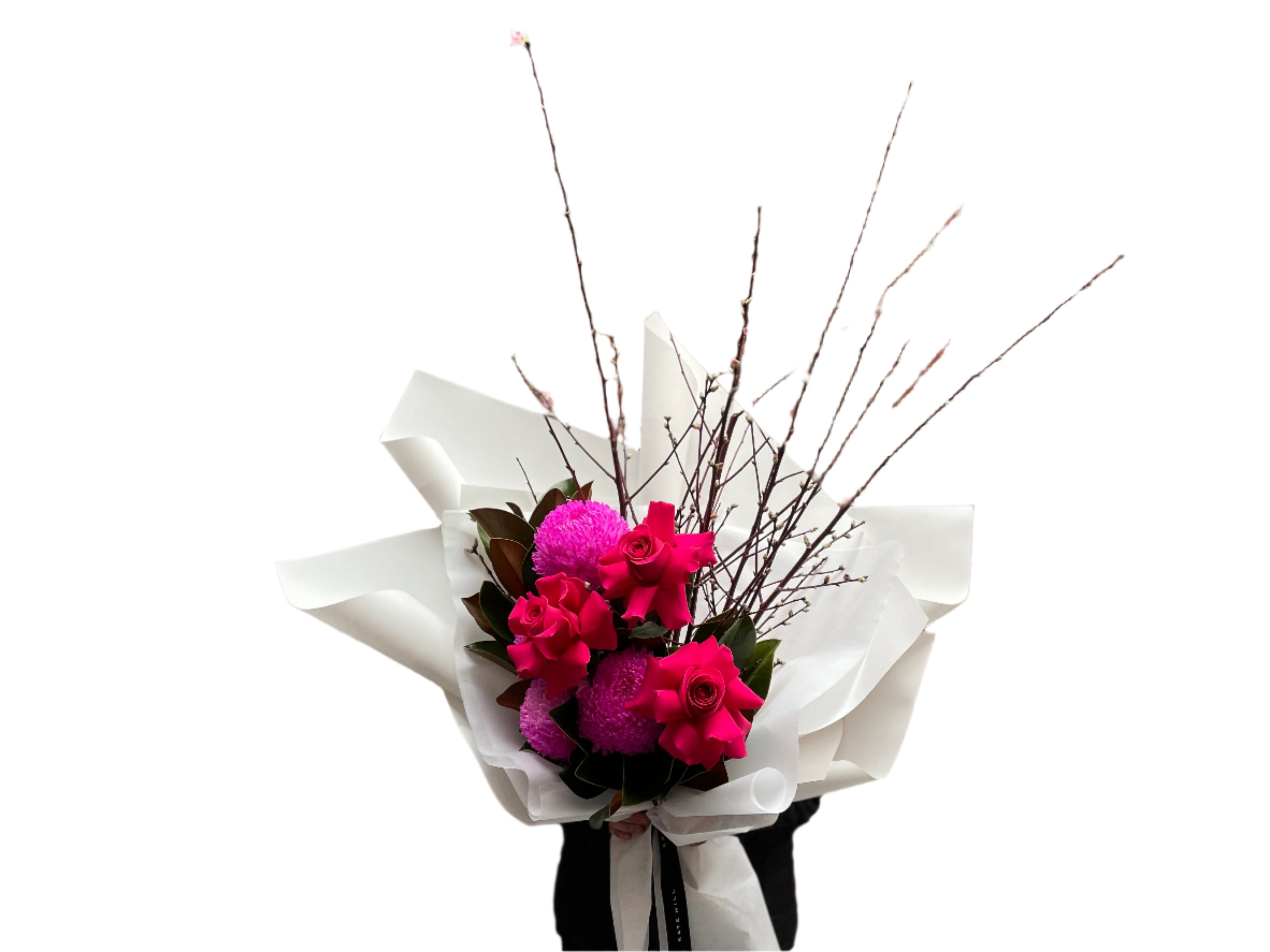 A Melbourne florist wearing black holding a bouquet of flowers with hot pink flowers wrapped in white paper against a white wall.