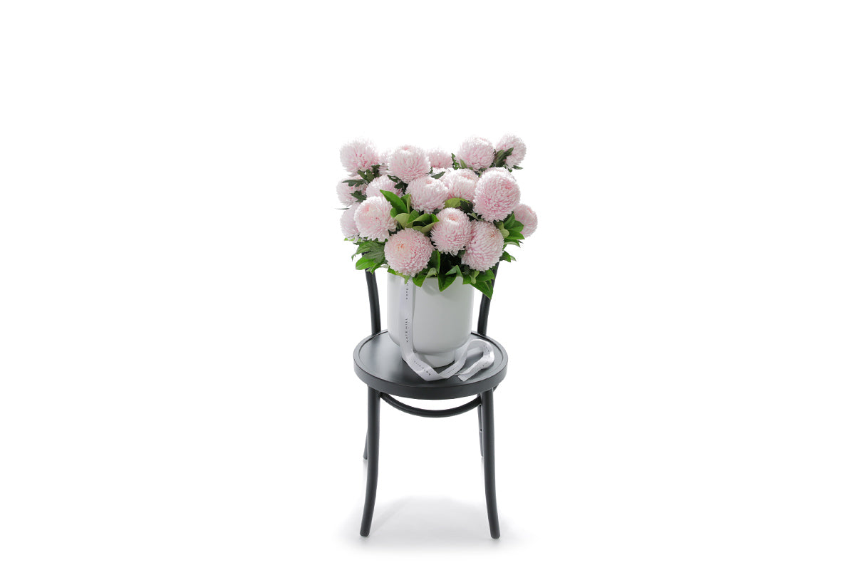 VIVIENNE 20 soft pink disbuds in a large white footed ceramic vessel