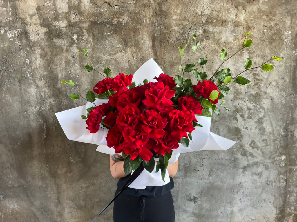 Lady holding bouquet of red roses