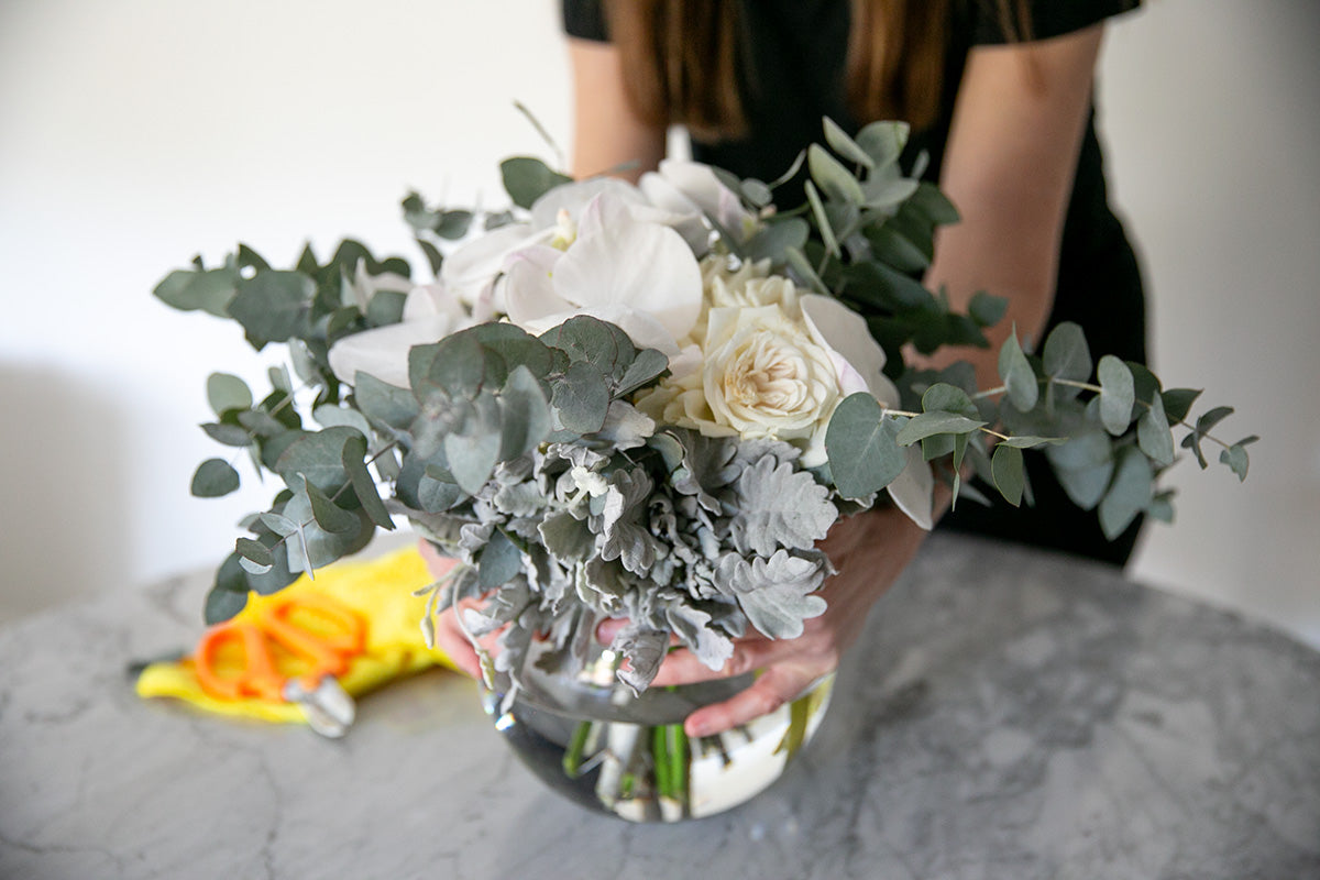 Women caring for flower arrangement on table