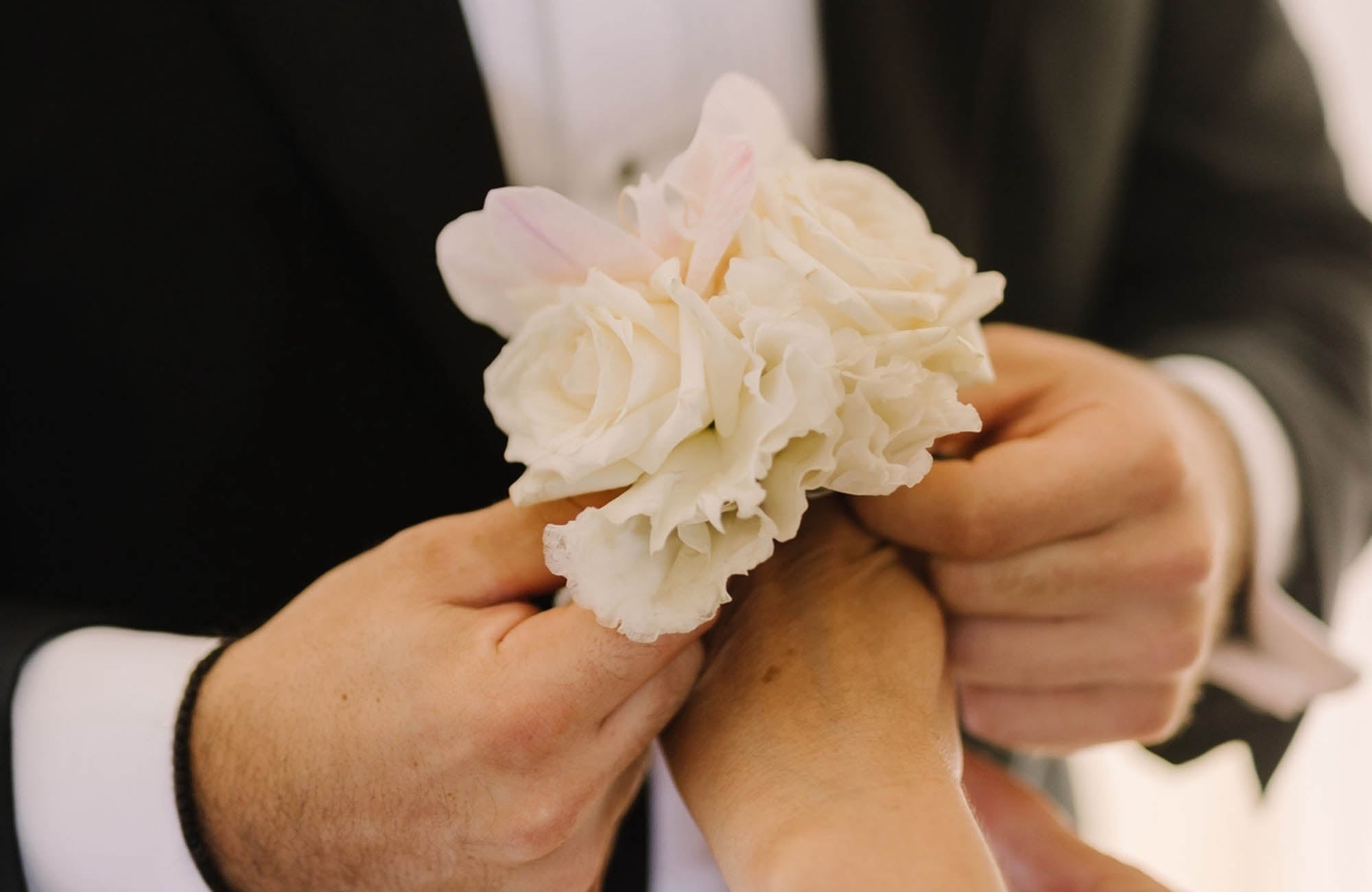 Wrist corsage being fitted on arm for school formal