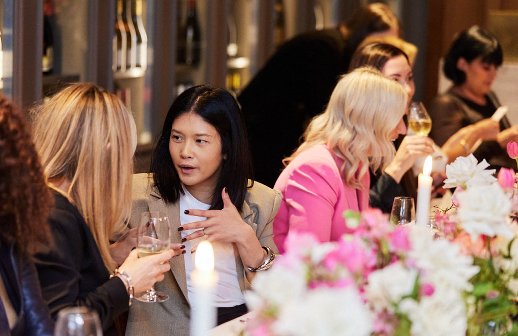 Women at luncheon talking with the table decorated in Flowers