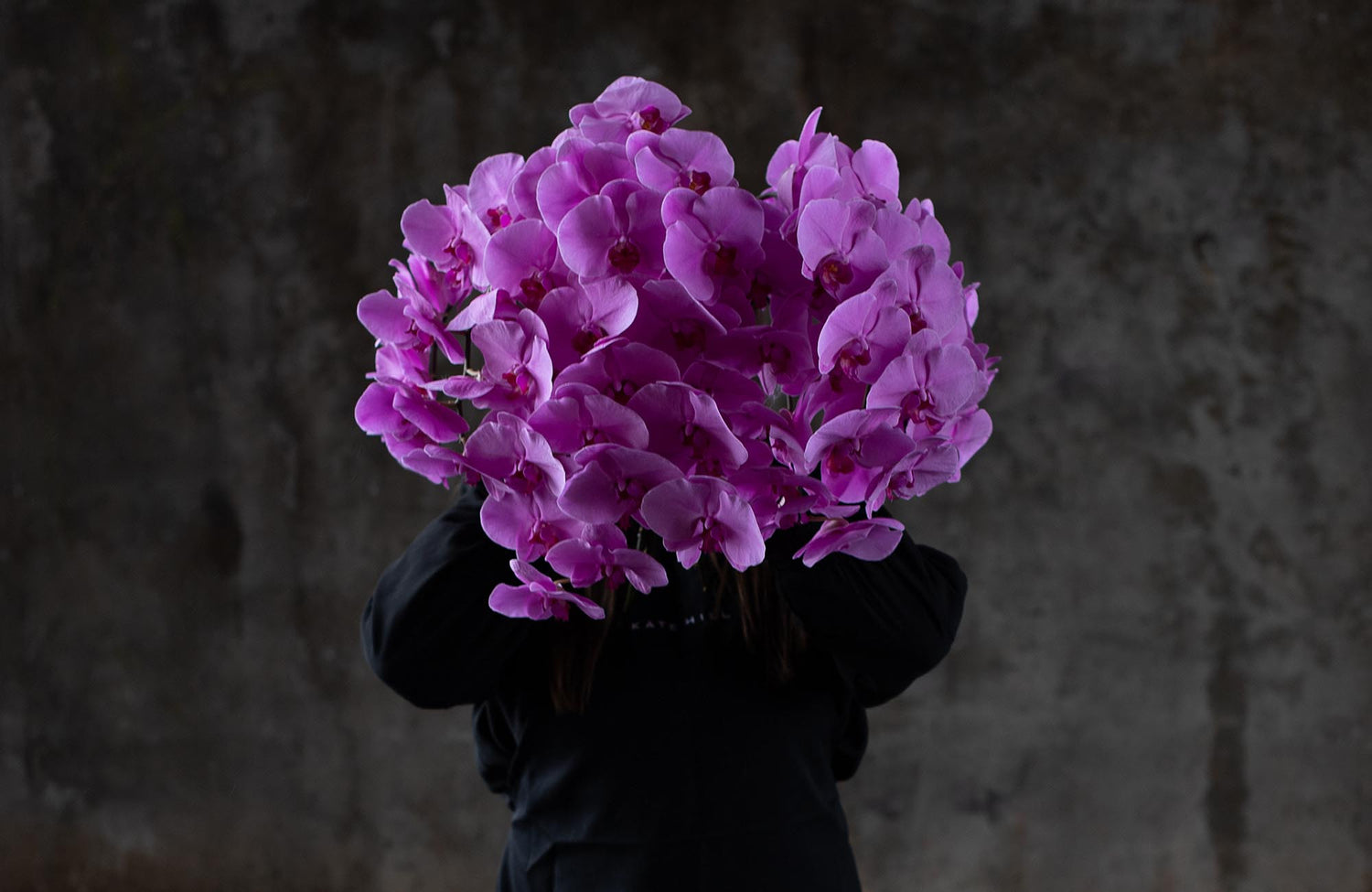 Melbourne Florist Kate Hill holding up Pink Phalaenopsis Orchids