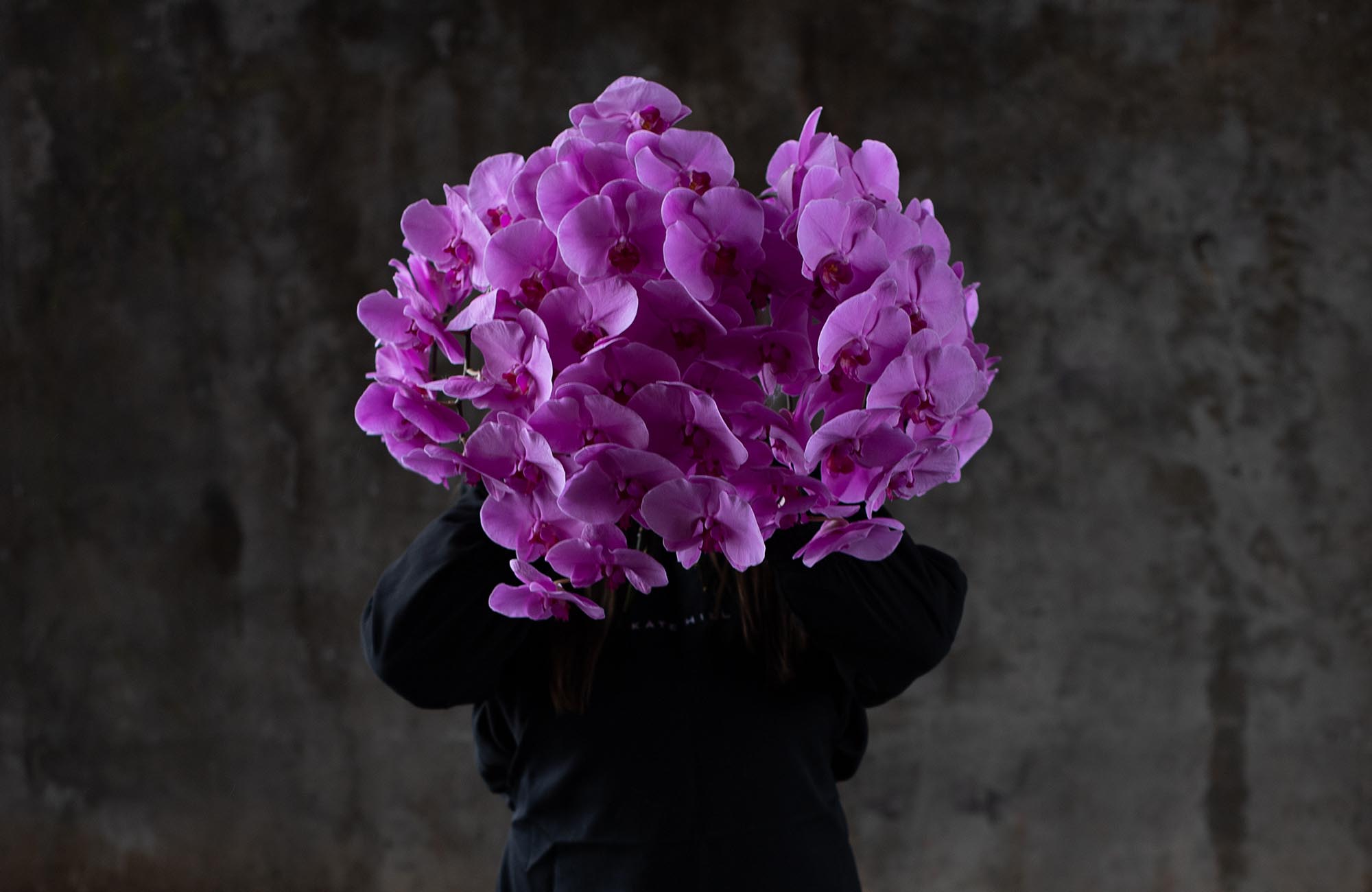 Melbourne Florist Kate Hill holding up Pink Phalaenopsis Orchids