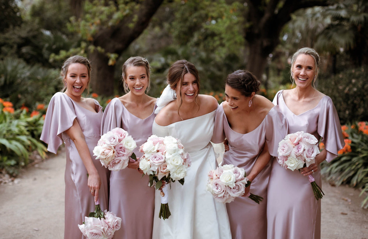 Bridesmaids holding reflexed rose bridal bouquets