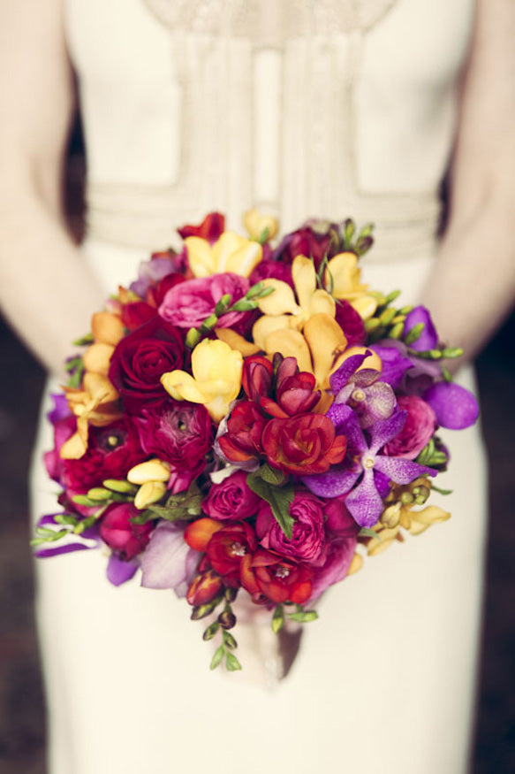 Bride holding bridal bouquet at Melbourne wedding with Rich colours including burgundies and purples and oranges.
