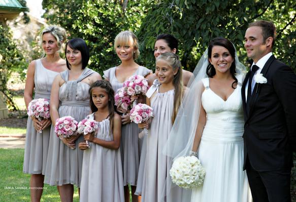 Wedding party standing holding bridal flowers in garden setting in Melbourne