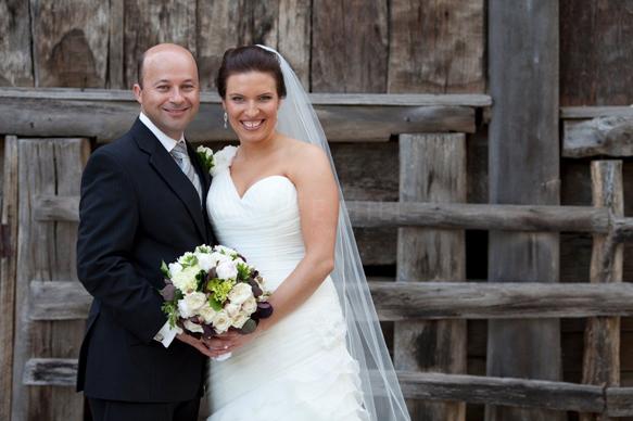 Sarah and Anthony standing at wedding Reception together with Sarah holding bridal flowers