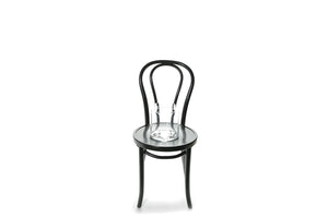 20cm lipped cylinder vase sitting on a black bentwood chair with a white background.