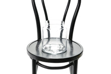 Close up image of glass vase. 20cm lipped cylinder vase sitting on a black bentwood chair with a white background.