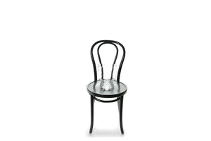 Large 24cm compote glass vase sitting on a black bentwood chair with a white background.