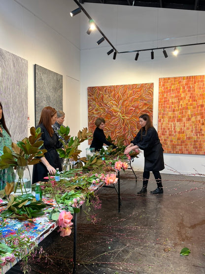 Kate Hill hosting a flower workshop at plume art gallery. A group of ladies watching Kate mentor the group on how to design with lowers.