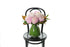 A mushroom vase, lined with green monsteria leaves, displying pink blush disbuds and a hint of foliage. Vase deisign sitting on a black bentwood chair with a white background.