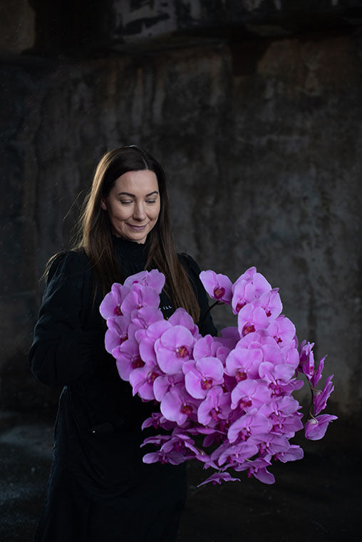 Florist holding bouquet of pink orchids for delivery to Armadale 