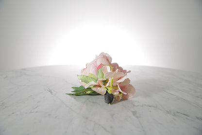 Kate Hill Flowers – pink spray rose buttonhole flowers with black-taped stem and pearl pin on marble table setting.