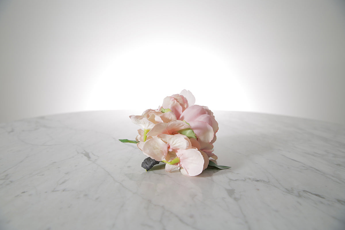 Kate Hill Flowers – pink spray rose buttonhole flowers with black-taped stem and pearl pin on marble table setting.