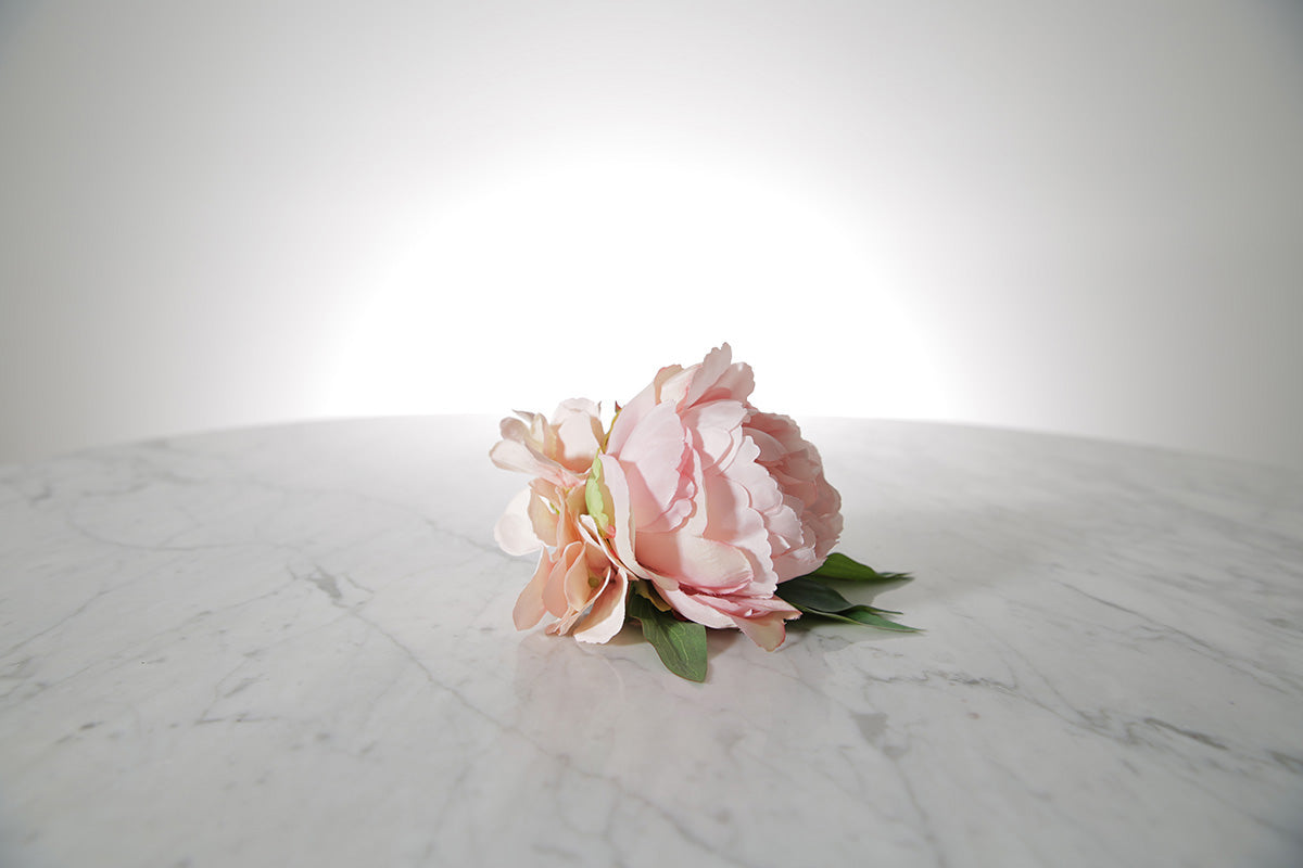 Kate Hill Flowers – pink spray rose buttonhole flowers with black-taped stem and pearl pin on marble table setting.
