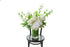 Tall glass vase, lined with green leaves, featuring seasonal white and green flowers. Large vase design sitting on black bentwood chair with white background.
