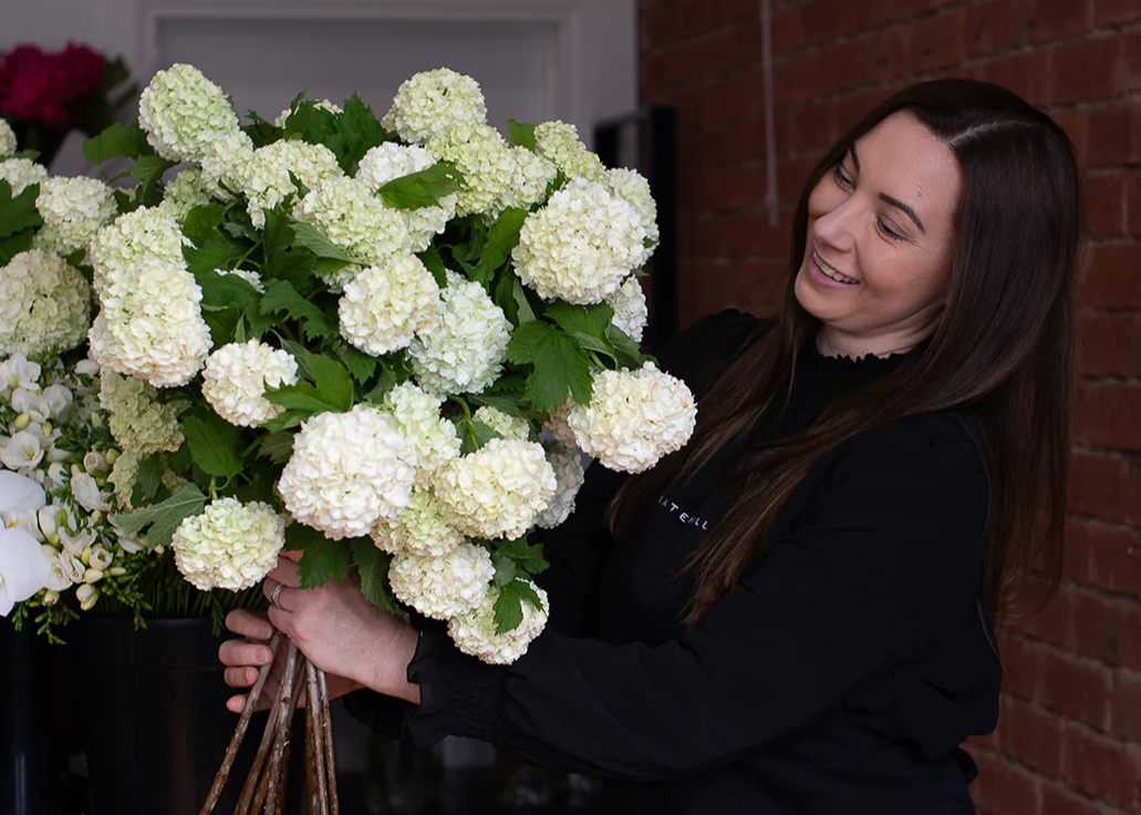 Melbourne Florist Kate Hill holding a bunch of Hydrangea flowers in her Melbourne Flower Shop