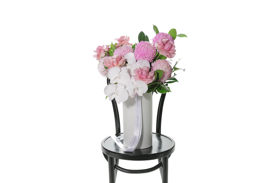 Kate Hill Flowers – large soft-pink ceramic vase arrangement with roses, chrysanthemums, orchids and rich greenery.