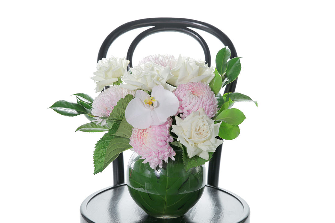 Kate Hill Flowers – pastel ball-vase birthday design with blush chrysanthemums, white roses, orchids and lush foliage.