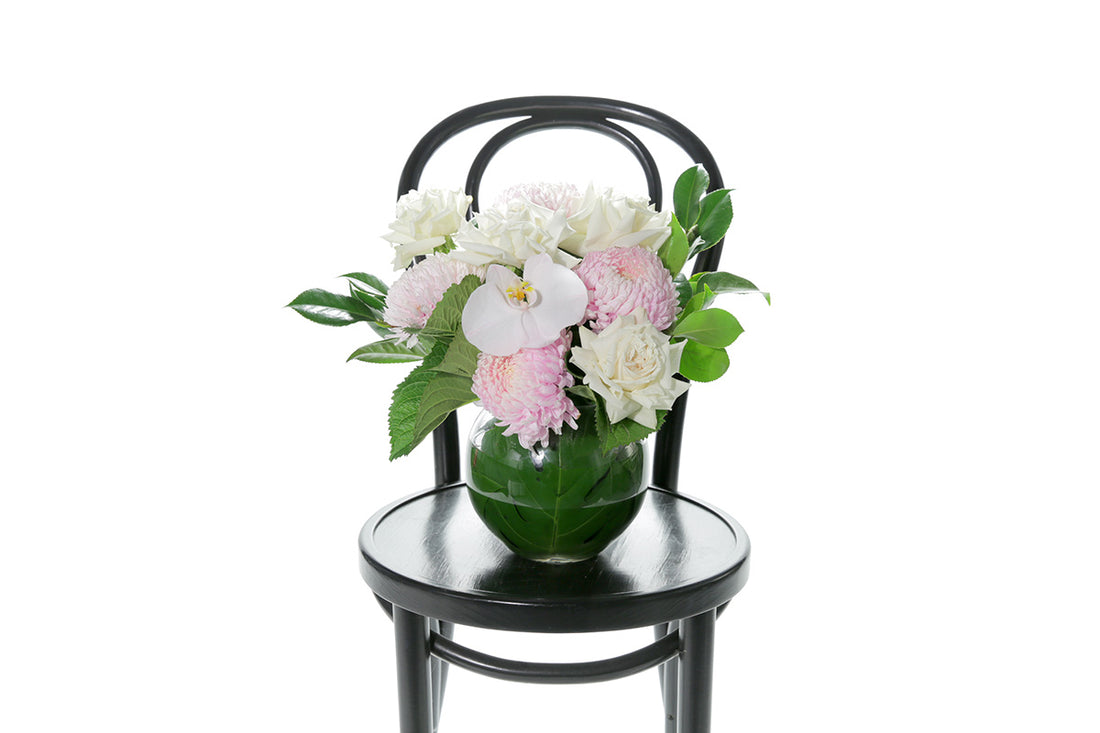 Kate Hill Flowers – pastel ball-vase birthday design with blush chrysanthemums, white roses, orchids and lush foliage.